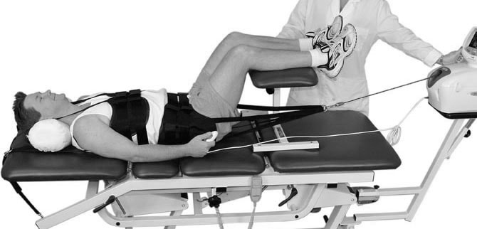 Patient getting physiotherapy treatment for sciatica Diagram of Physiotherapist treating patient with sciatica by mechanical spinal traction method